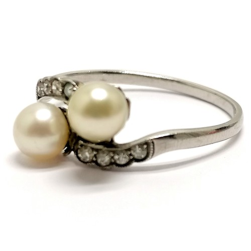 610 - Unmarked (touch tests as 18ct) white gold crossover pearl ring with diamond set shoulders - size U &... 