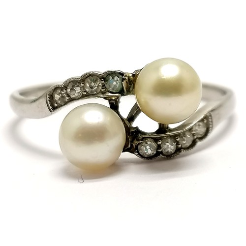 610 - Unmarked (touch tests as 18ct) white gold crossover pearl ring with diamond set shoulders - size U &... 