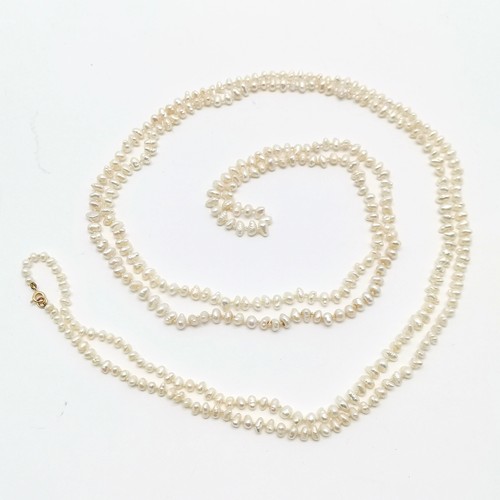 677 - Long strand (164cm) of freshwater pearls with 9ct gold clasp