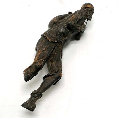 167 - Antique carved wooden figure of an eastern gentleman carrying a sack - 44cm high - has obvious losse... 