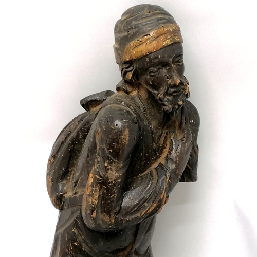 167 - Antique carved wooden figure of an eastern gentleman carrying a sack - 44cm high - has obvious losse... 