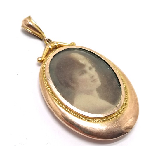 317 - Antique 9ct marked gold oval locket photo pendant - 5.8cm drop & 7.7g total weight and has wear and ... 