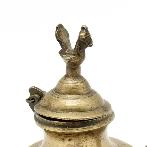 64 - Asian metal ghee oil vessel with peacock bird detail to hinged lid - 15cm high