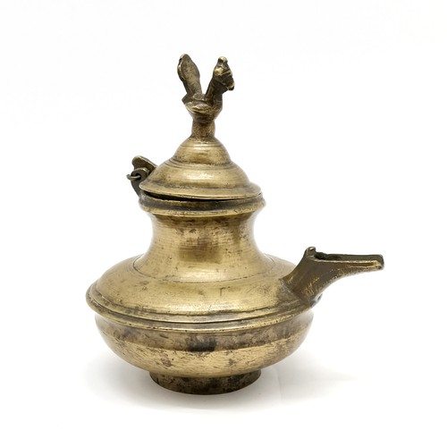 64 - Asian metal ghee oil vessel with peacock bird detail to hinged lid - 15cm high