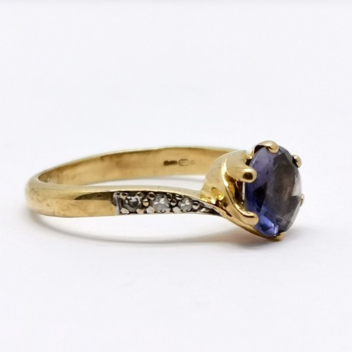 554 - 9ct hallmarked gold iolite (?) / diamond crossover ring - size L & 1.9g total weight - stone has wea... 