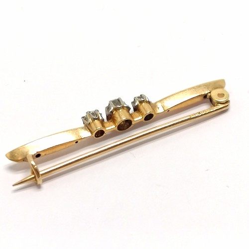 555 - Antique indistinctly marked (18ct) gold bar brooch set with 3 diamonds - 4cm & 2.4g total weight