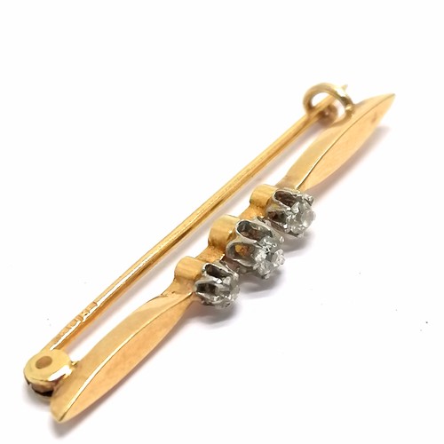 555 - Antique indistinctly marked (18ct) gold bar brooch set with 3 diamonds - 4cm & 2.4g total weight