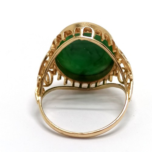 621 - Unmarked gold (touch tests as 14ct) jade stone set ring with fancy open work shoulders - size O½ & 4... 