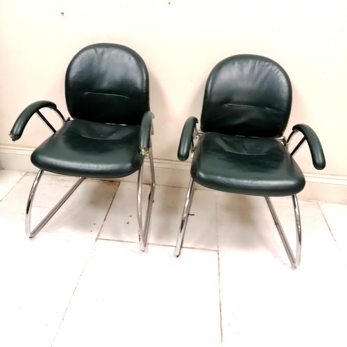 284 - Mid century pair of Eames? office chairs upholstered in green leather - 1 has both arms with chew ma... 