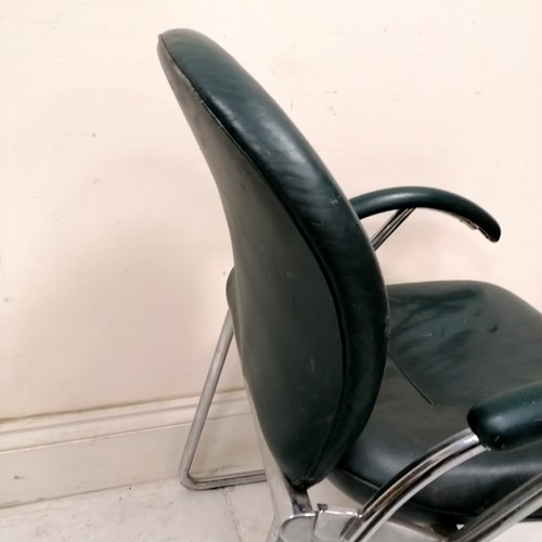 284 - Mid century pair of Eames? office chairs upholstered in green leather - 1 has both arms with chew ma... 