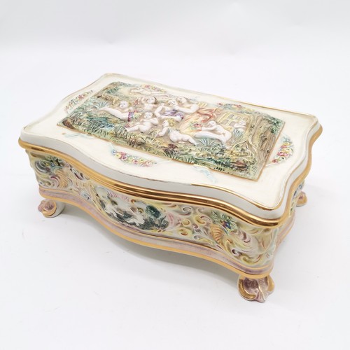 363 - Capodimonte porcelain large table box with cherubic detail terminating on 4 acanthus leaf detail fee... 