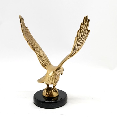 416 - Brass cast figure of a bird of prey on a black marble base 24cm high  x 19cm wide