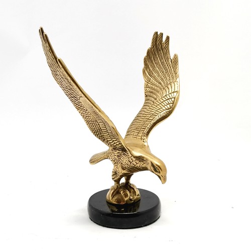 416 - Brass cast figure of a bird of prey on a black marble base 24cm high  x 19cm wide