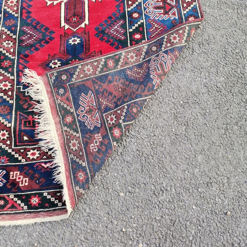 274 - Turkish dosemealti blue grounded wool rug with red medallions to the centre - 121cm x 210cm