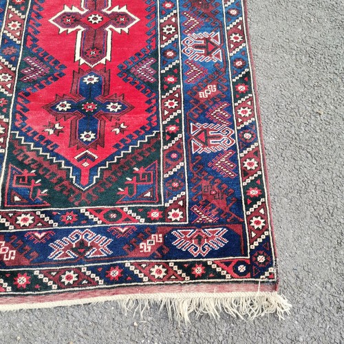 274 - Turkish dosemealti blue grounded wool rug with red medallions to the centre - 121cm x 210cm