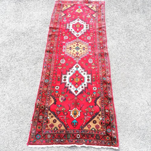 181 - Iranian red grounded wool runner with 3 central meddalions and floral detail 280cm x 100cm - has som... 