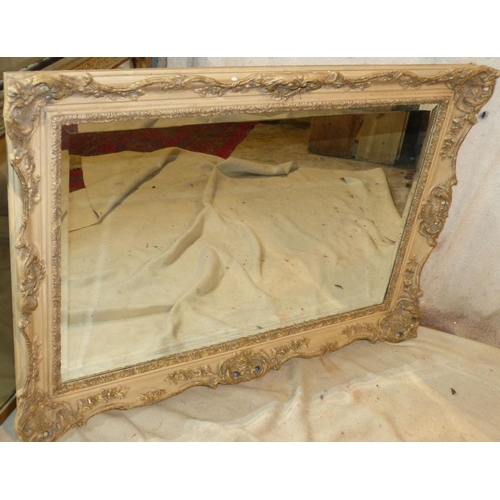 828 - A White Painted Hanging Rectangular Bevelled Wall Mirror with raised and pierced floral and scroll d... 