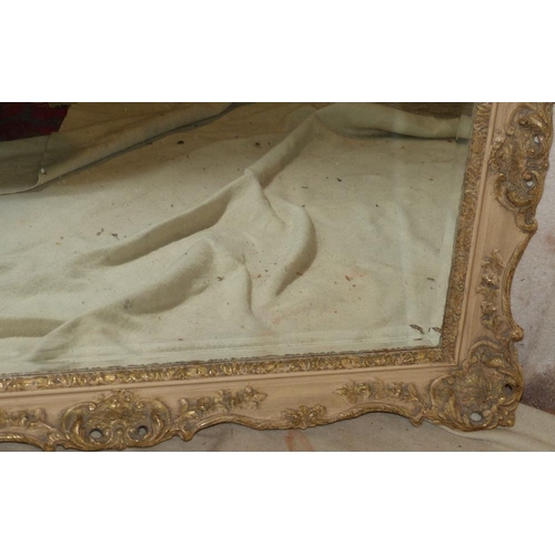 828 - A White Painted Hanging Rectangular Bevelled Wall Mirror with raised and pierced floral and scroll d... 