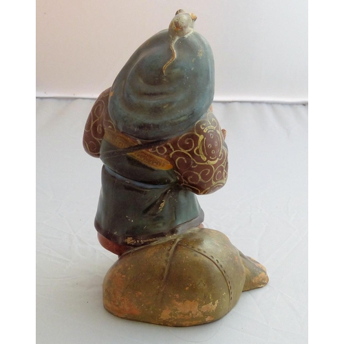 121 - An Oriental Earthenware Figure of a gentleman standing next to bag with rat upon his head, 18.5cm hi... 