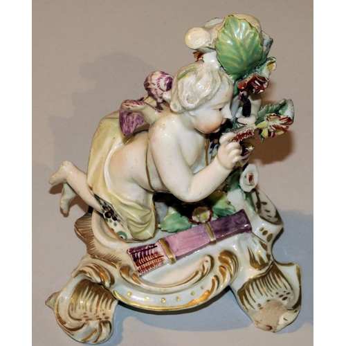 184 - An 18th Century Derby Figure of a Kneeling Cupid, with encrusted floral decoration, 14cm high (chips... 