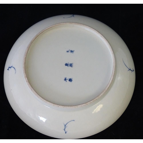 204 - An Oriental Round Plate on blue and white ground having fish decoration, 22.5cm diameter  