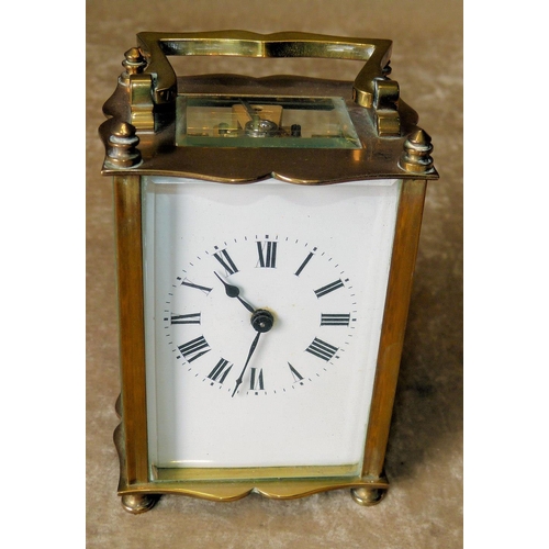 632 - A Brass Carriage Clock having swing overhead handle, white enamel dial with turned feet, 11.5cm high... 