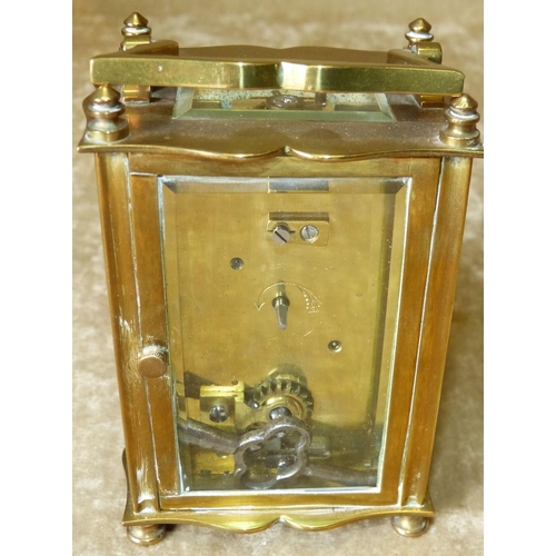 632 - A Brass Carriage Clock having swing overhead handle, white enamel dial with turned feet, 11.5cm high... 