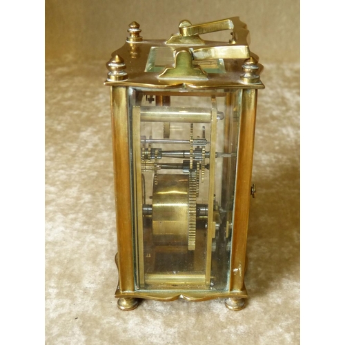 632 - A Brass Carriage Clock having swing overhead handle, white enamel dial with turned feet, 11.5cm high... 