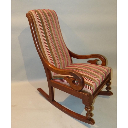 652 - A Victorian Mahogany Rocking Chair having striped overstuffed seat and back with scroll arms  