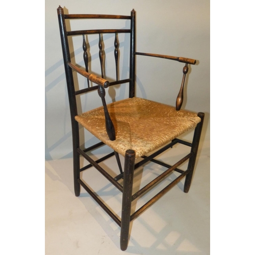 653 - A William Morris Style Stick Back Armchair having rush seat on round legs  