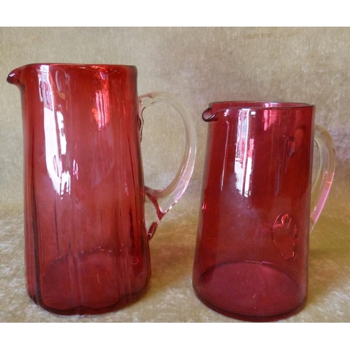 82 - A Cranberry Glass Jug, 19cm high, also a smaller Cranberry glass jug, 16cm high (2)  