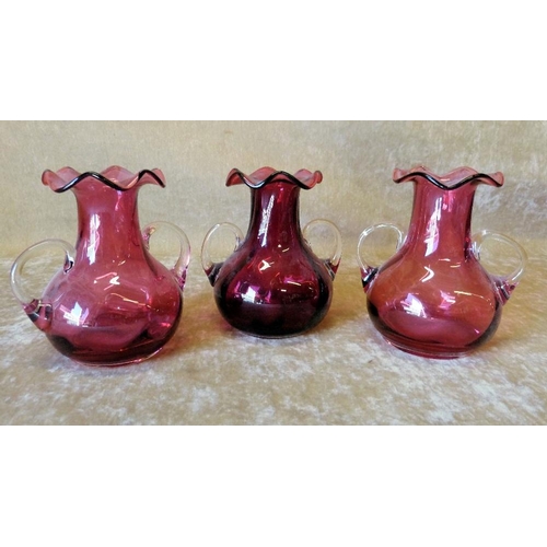 84 - A Set of 3 Cranberry Glass Bulbous  2-Handled Trumpet Shape Vases having crinkle rims, 13cm high (3)... 