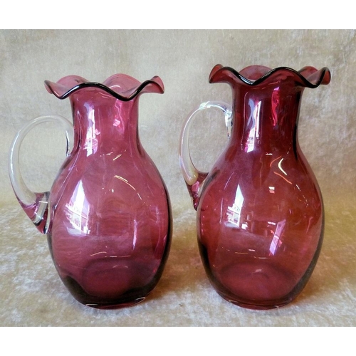 96 - 2 Cranberry Bulbous Trumpet Shape Jugs having crinkled rims with clear glass handles, largest 21.5cm... 