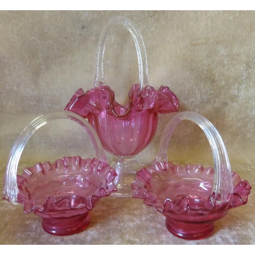 99 - 2 Similar Cranberry Glass Baskets having crinkle rims with clear reeded overhead handles, also a lar... 