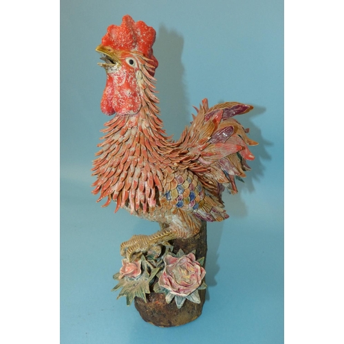 27 - An Oriental Earthenware Figure of a Cockerel having all over raised encrusted decoration, 40cm high