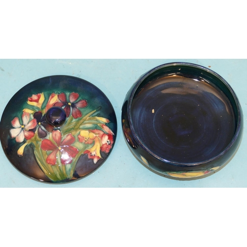 111 - A Moorcroft Round Bulbous Lidded Dressing Table Pot on blue ground with multicoloured floral and lea... 