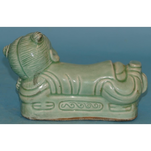 65 - An Oriental China Pillow inform of a child on pale green ground, 22cm wide.