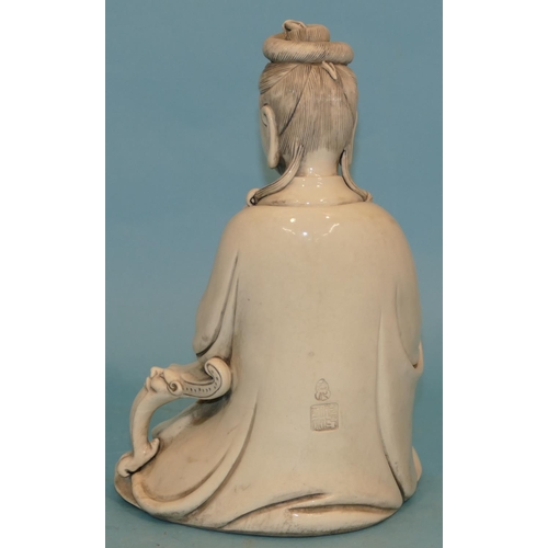 67 - An Oriental Blanc-de-chine Figure of a seated goddess holding a scroll, 26.5cm high.