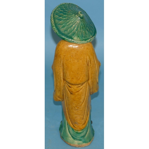 68 - An Oriental Pottery Figure of a gentleman holding a scarf, 27cm high.