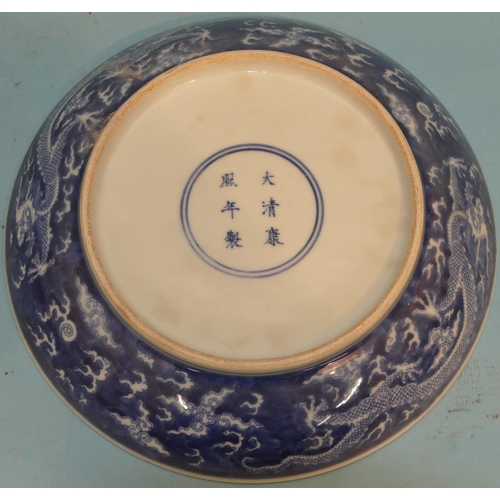 72 - An Oriental Round Plate on blue and white ground with dragon decoration, 24cm diameter.