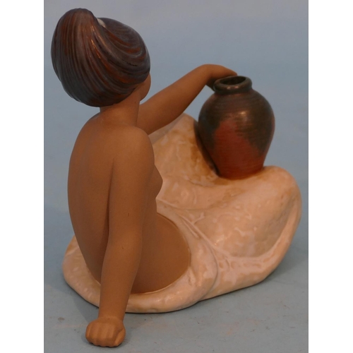 28 - A Lladro Glazed Earthenware Figure of a reclining half naked lady holding a vase, 22cm long.