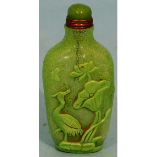 50 - A Green Glass Peking Style Snuff Bottle with stopper having raised bird and fish decoration, 8cm hig... 