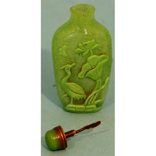 50 - A Green Glass Peking Style Snuff Bottle with stopper having raised bird and fish decoration, 8cm hig... 