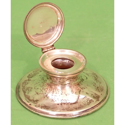 219 - A Birmingham Silver Round Inkwell having hinge lid with sweeping base (base dented) 10.5cm diameter.