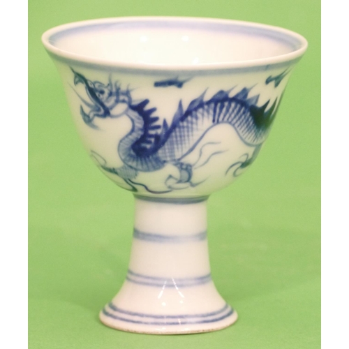 22 - An Oriental Blue and White Round Cup having dragon decoration on sweeping foot, 9cm high.