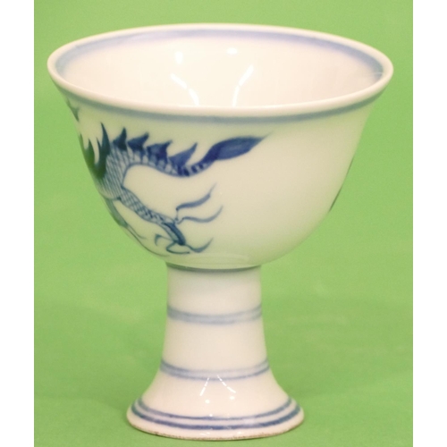 22 - An Oriental Blue and White Round Cup having dragon decoration on sweeping foot, 9cm high.