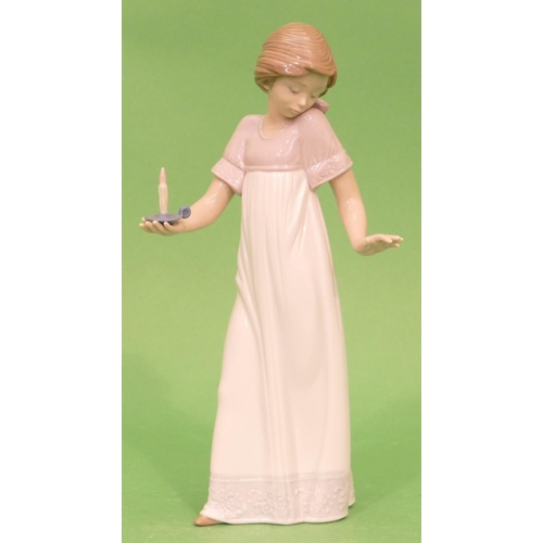 27 - A Nao Figure of a young girl holding chamber candlestick, 26.5cm high.