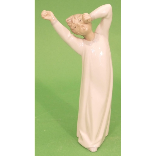 41 - A Lladro Figure of a young boy in nightdress stretching and yawning, 22cm high.