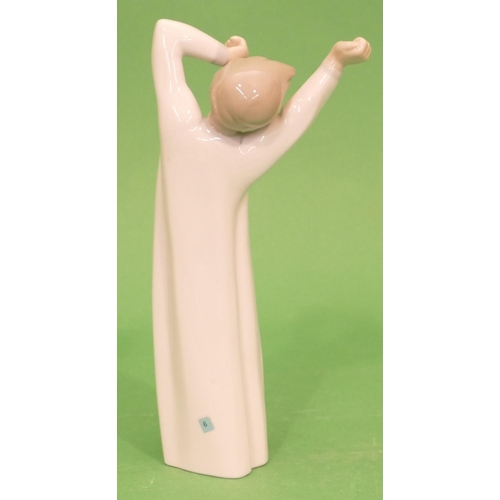 41 - A Lladro Figure of a young boy in nightdress stretching and yawning, 22cm high.