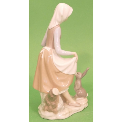 44 - A Lladro Group of a young lady with rabbit at her feet, 23cm high.